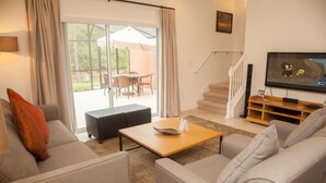 A modern living room with a sofa set, a coffee table, and a TV. - Ly86465 - Encantada Resort - 2 Bed 2 Baths Townhome (Kissimmee)