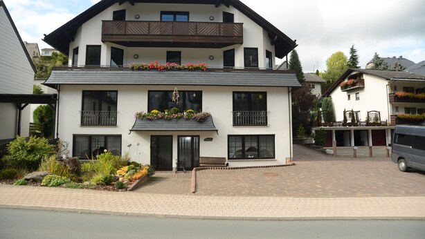 A two-story building with a balcony, large windows, and flower boxes. - Hotel Leise Garni Willingen (Willingen)