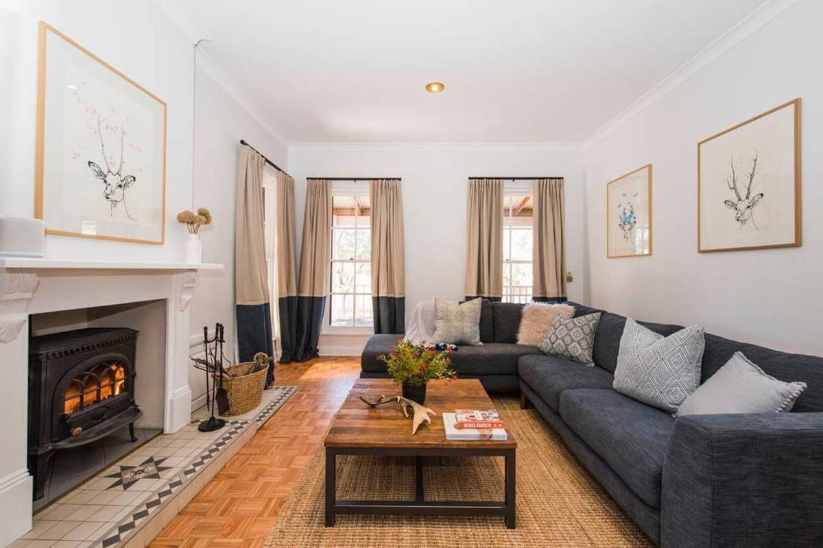A living room with a fireplace, a dark grey sofa, and a coffee table.