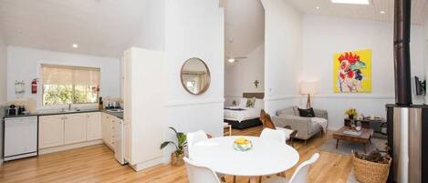 A modern, open-plan living space with a kitchen, dining area, and a cozy seating area.