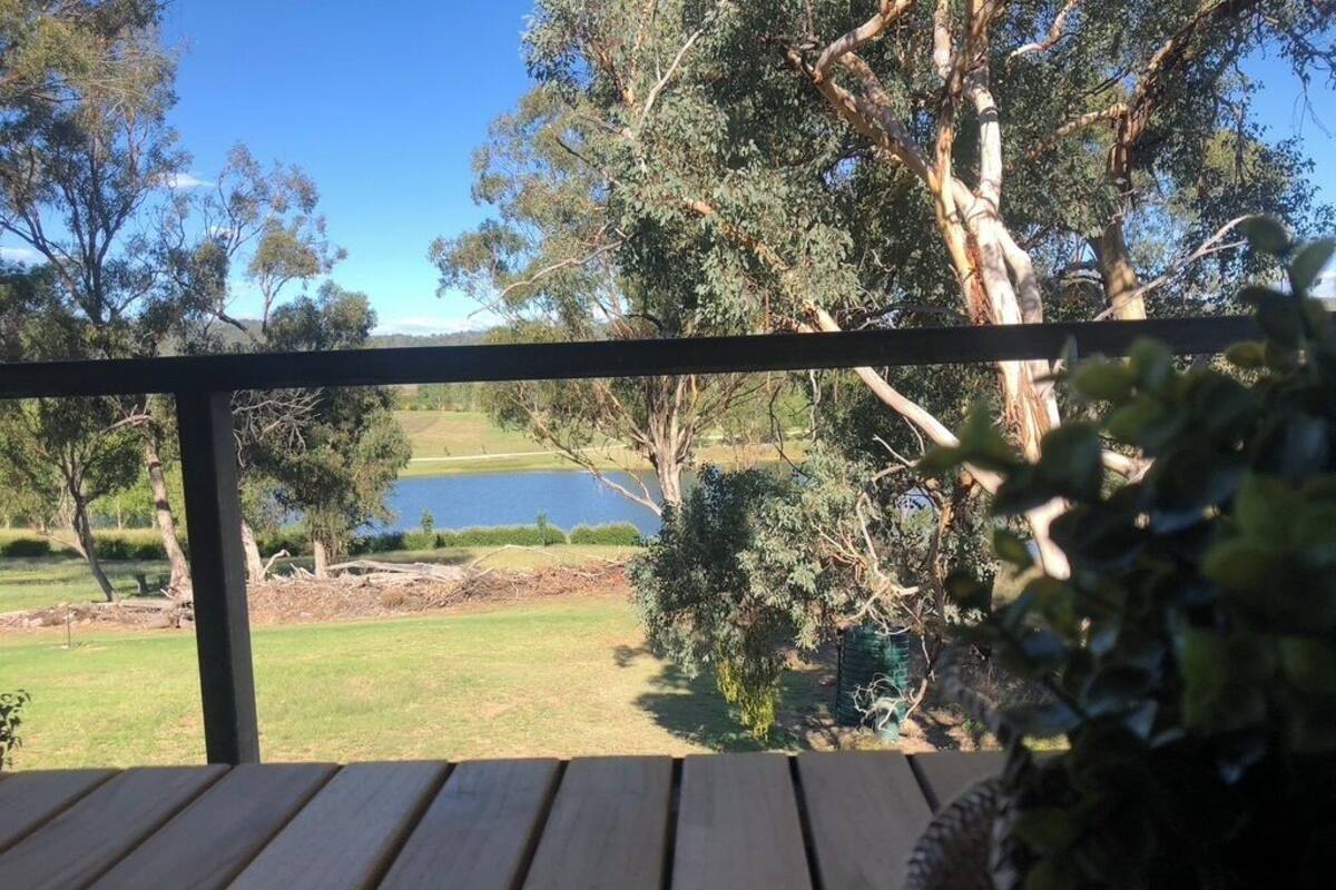 A wooden deck with a view of a lake and trees.
