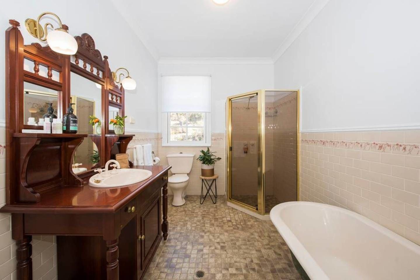 A bathroom with a wooden vanity, a toilet, a shower with a glass door, and a bathtub.