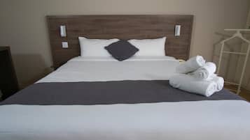 Escritorio, cortinas blackout y tabla de planchar con plancha