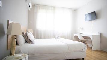 Escritorio, cortinas blackout y tabla de planchar con plancha