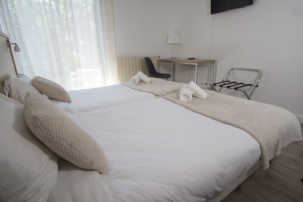 Une chambre d’hôtel avec un grand lit, un bureau, une chaise et un porte-serviettes.