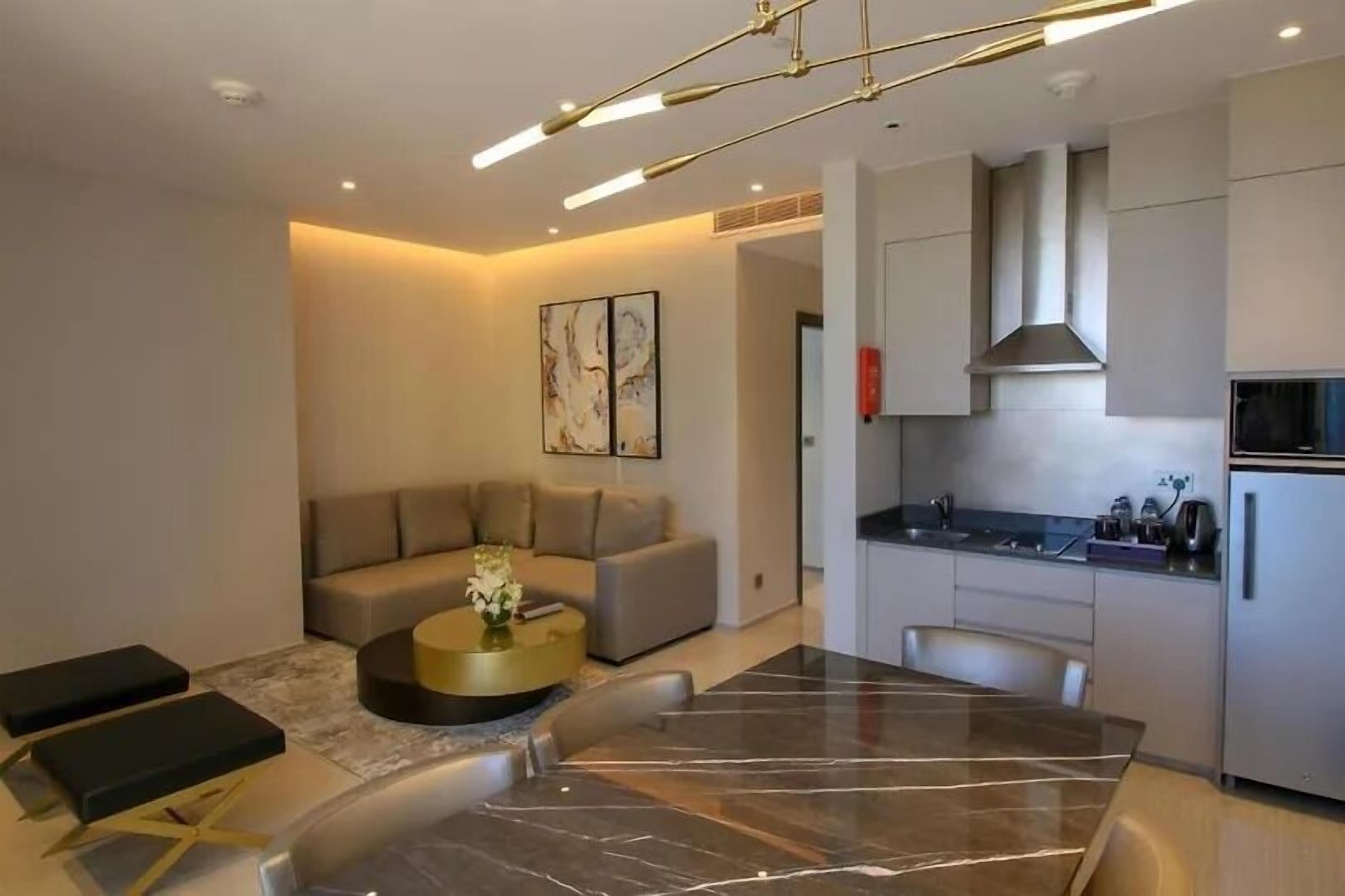 A modern living room with a marble dining table, a sofa, and a coffee table.
