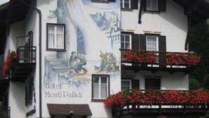 Een gebouw met een grote banner waarop 'Hotel Monti Pallidi' staat aangekondigd.