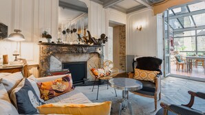 Una sala de estar acogedora con chimenea, asientos cómodos y vistas amplias a través de un gran ventanal.