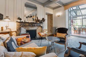 Una sala de estar acogedora con chimenea, asientos cómodos y vistas amplias a través de un gran ventanal.
