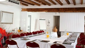 A conference room with a long table set for a meeting, red chairs, and a whiteboard. - Les Clos de Chaponost (Chaponost)