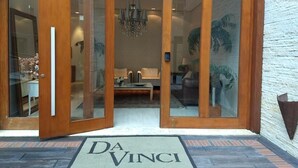 L’entrée d’un hôtel, avec une porte en bois et un panneau de verre.