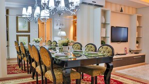 Un espace repas avec une longue table, des chaises et un lustre.