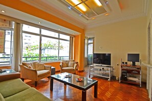 Departamento, varias camas | Área de sala de estar | Televisión de pantalla plana