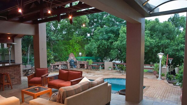Ein Terrassenbereich im Freien mit Pool, Sitzgelegenheiten und Grill.