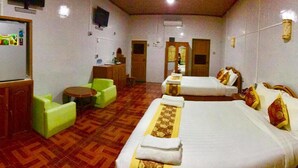A hotel room with a bed, a desk, a chair, a small table, and a mirror. - Nan Htike Yadanar Hotel (Monywa)