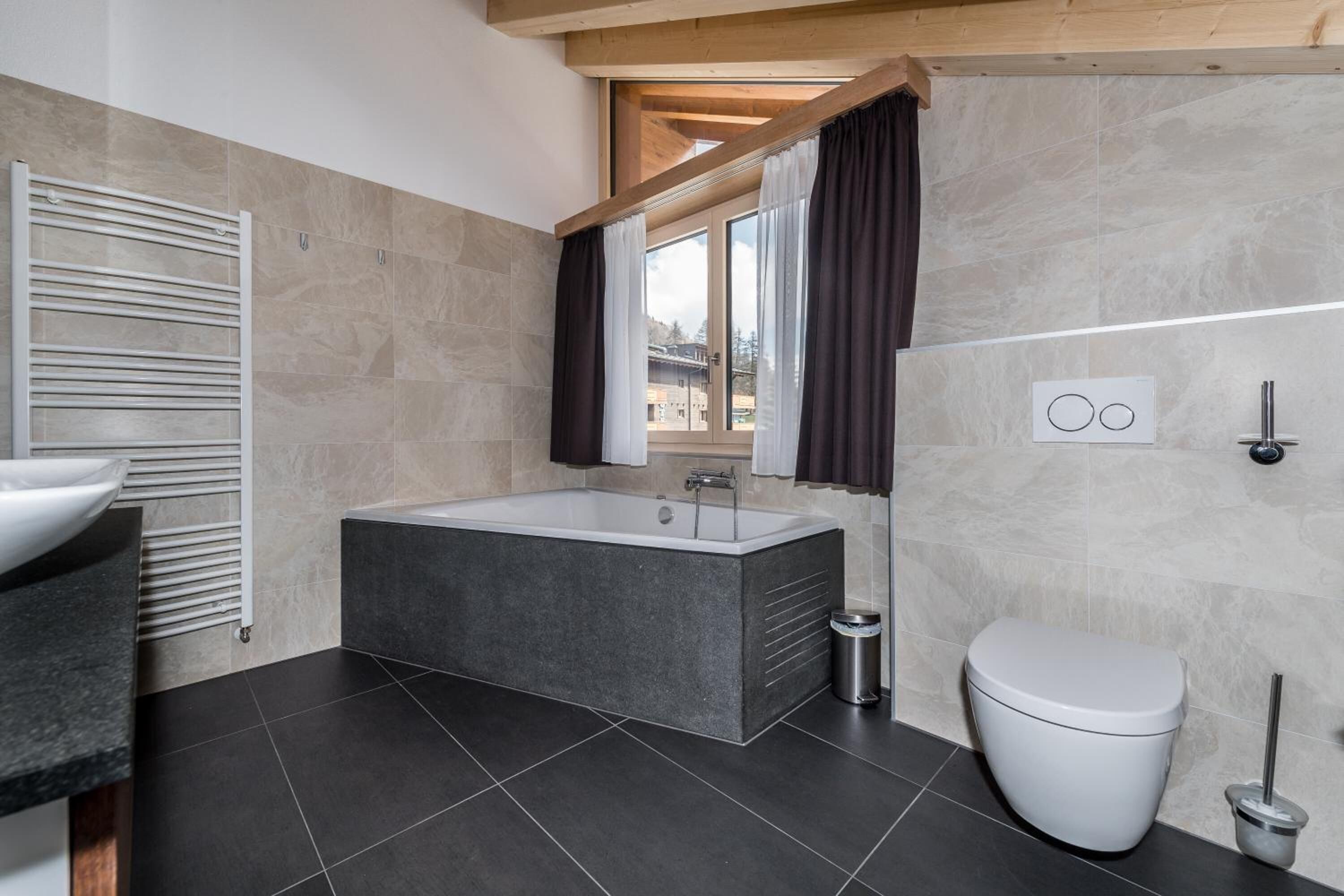 A modern bathroom with a freestanding bathtub, a toilet, and a sink.