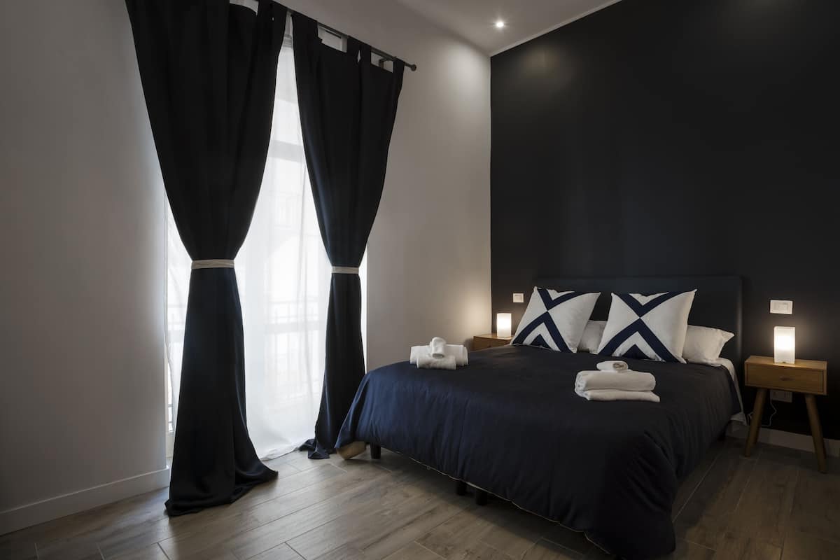 Habitación cuádruple Deluxe, balcón | Edredón, camas con efecto memoria, muebles diferentes y escritorio