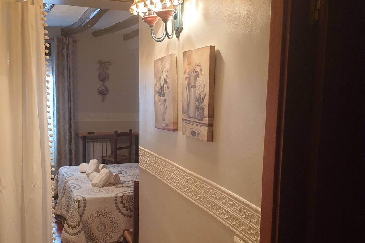 Um corredor com uma cama, um abajur e obras de arte na parede.