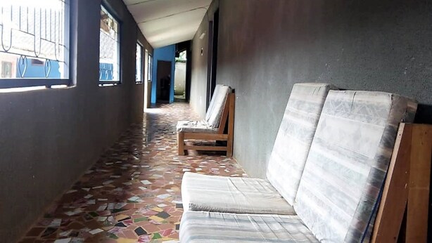 A corridor with patterned flooring, a bench, and a wall with a window.
