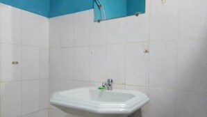 A bathroom with a white sink, blue wall, and white tiles.
