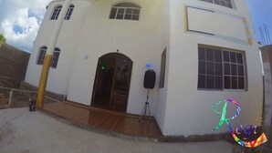 Un edificio blanco con fachada curva, un amplio arco de entrada y un balcón.