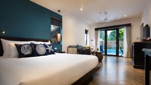 A modern hotel room with a large bed, a desk, a chair, and a view of the outdoors. - The Blue Alcove (Da Nang)