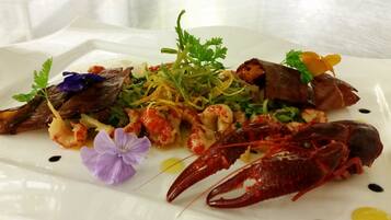 Un plato de mariscos con langosta, mejillones y otros mariscos sobre un plato blanco.