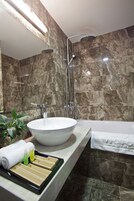 Un baño moderno con un lavamanos grande, una bañera y una ducha.