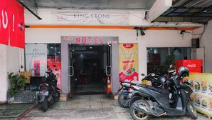 The exterior of a hotel with a sign reading "BAKMI AM" and a Coca-Cola refrigerator. - King Stone Hotel (South Tangerang)