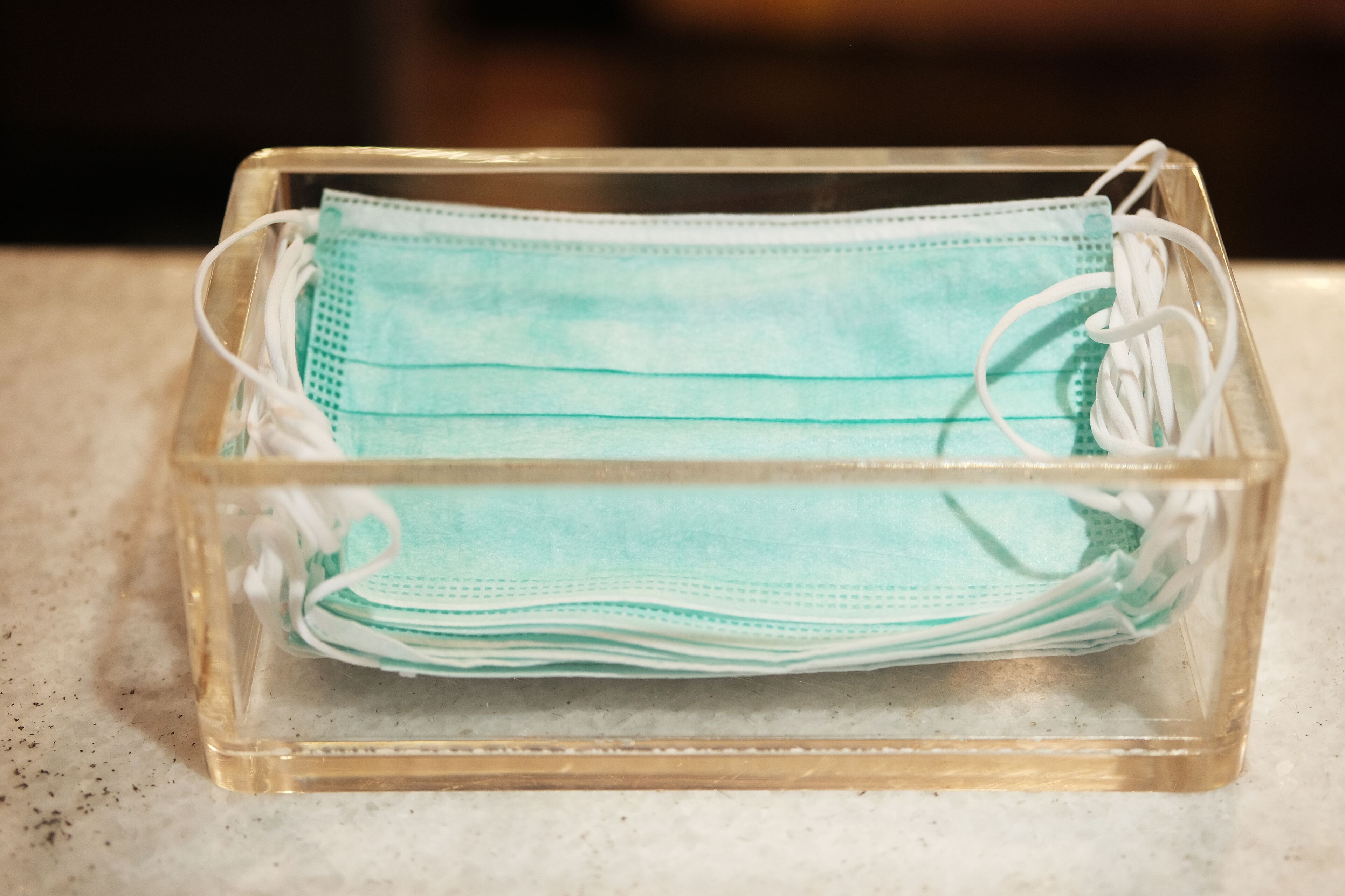 A clear plastic container holding multiple face masks.