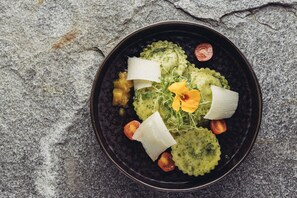 A bowl of food with various ingredients on a textured surface. - Genusshotel Vermala Montafon (Sankt Gallenkirch)