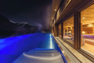 Una piscina al aire libre, sombrillas, tumbonas