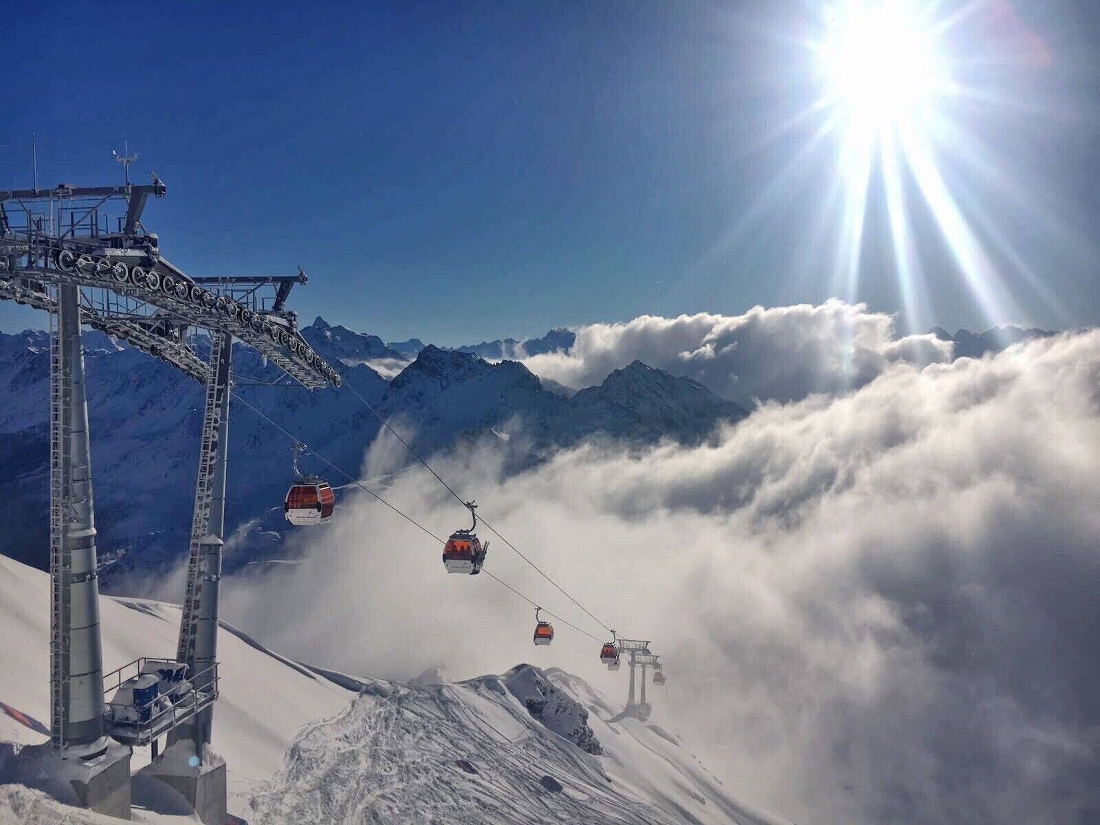 A cable car system with a clear sky and sun shining.