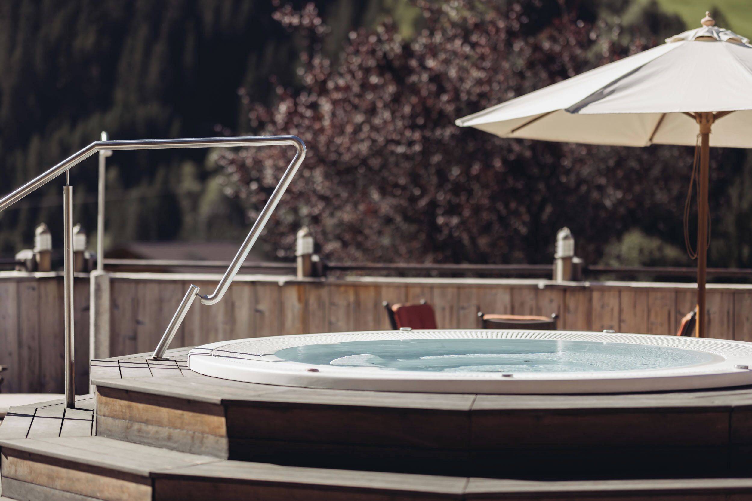 A hot tub with a metal ladder and a wooden deck.