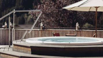 A hot tub with a metal ladder and a wooden deck.