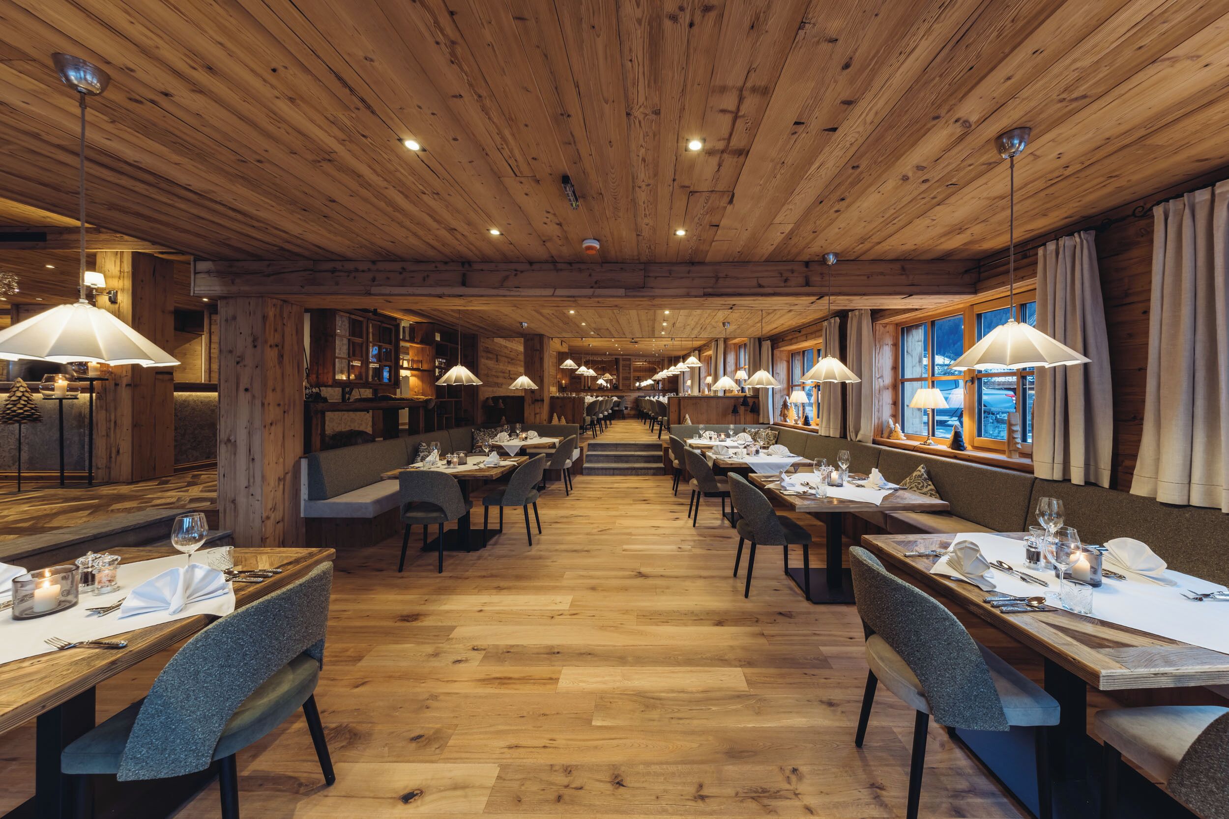 A restaurant with wooden ceilings and tables set for dining.