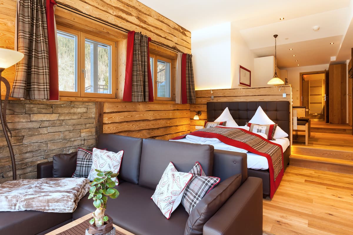 Una habitación acogedora con cama, sofá y ventana con cortinas.