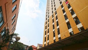 Un immeuble imposant, doté de nombreux étages et de balcons, et présentant un mélange de styles architecturaux.
