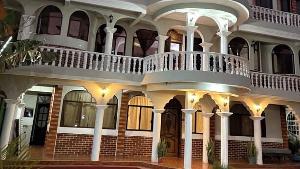 A multi-story building with balconies, a pool, and a brick facade. - Hotel Posada Gutierrez (Panajachel)