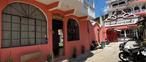 Un edificio de dos pisos con un balcón y un letrero que dice "HOTEL POSADA GUTIERREZ".