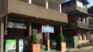 A building with a sign for 'Ilha' and 'O Novo Santo'. - Pousada O Meu Canto (Santa Rita de Jacutinga)