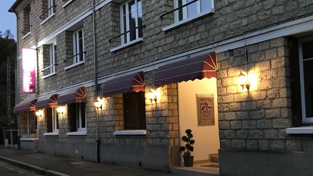 A stone building with a row of windows, awnings, and exterior lighting. - Hôtel les Iris (Les Andelys)