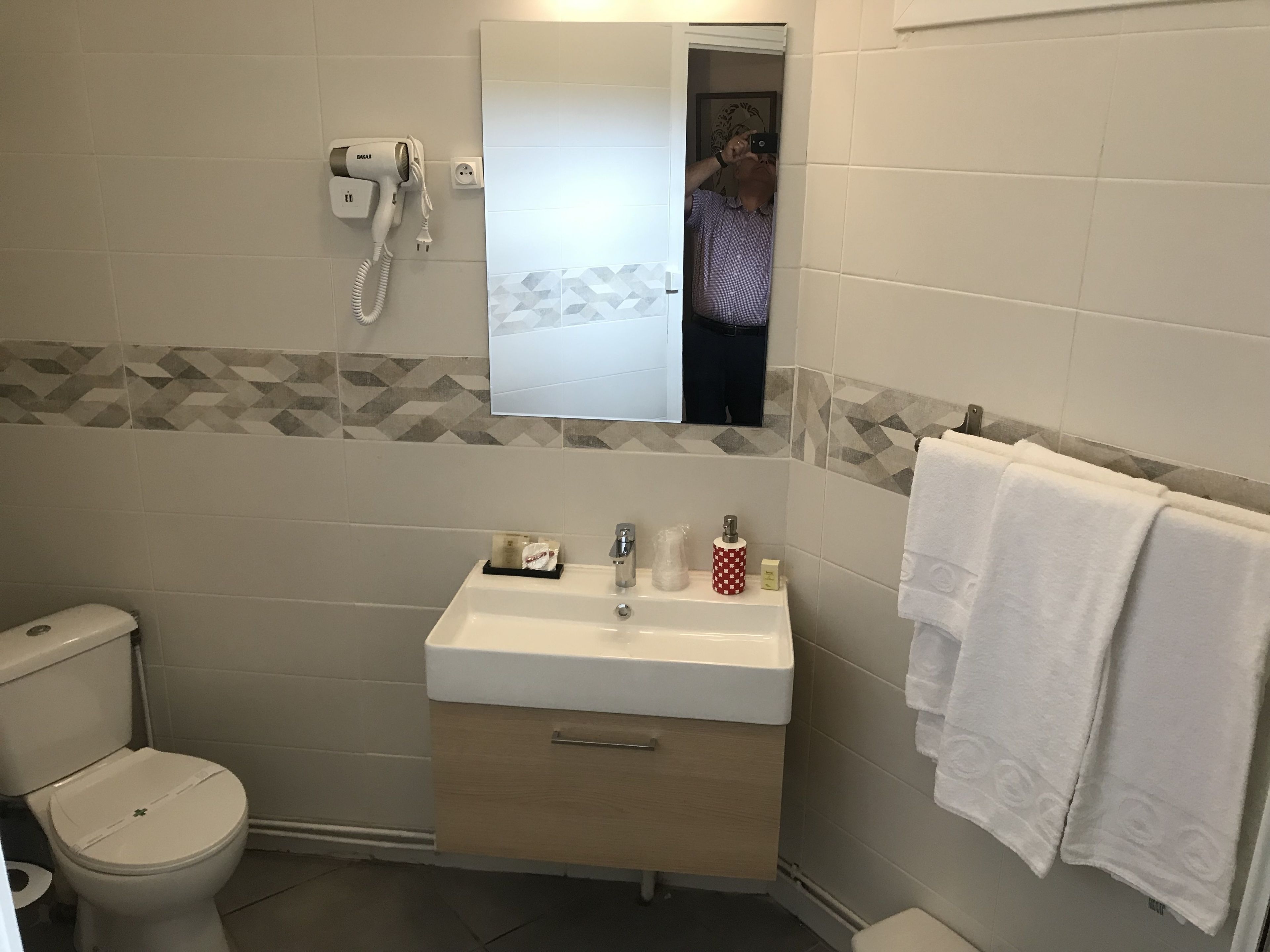 Un bagno con il water, un lavandino e un porta asciugamani.