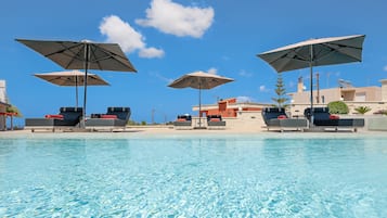 Een seizoensgebonden buitenzwembad, parasols voor strand/zwembad