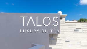 A sign for Talos Luxury Suites with a clear sky in the background. - Talos Luxury Suites (Chania)