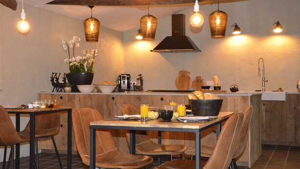 Une cuisine moderne avec des éléments en bois, un îlot central et des luminaires suspendus.