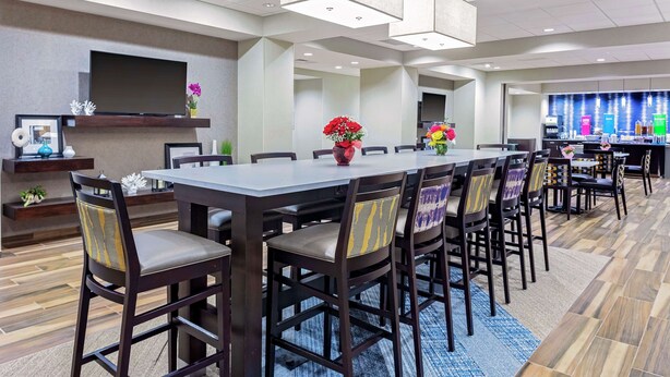A conference room with a long table, chairs, a TV, and a bar area. - Hampton Inn Cranbury (Cranbury)