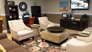 A living room with a sofa, two armchairs, a coffee table, and a television on the wall. - Ocean Key Resort spacious 1 bedroom suite (Virginia Beach)