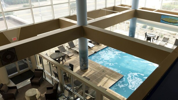 A multi-level indoor pool area with a view of the pool from the upper level. - Ocean Key Resort spacious 1 bedroom suite (Virginia Beach)