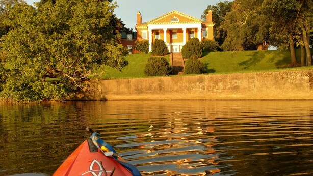 Un río con una casa al fondo.